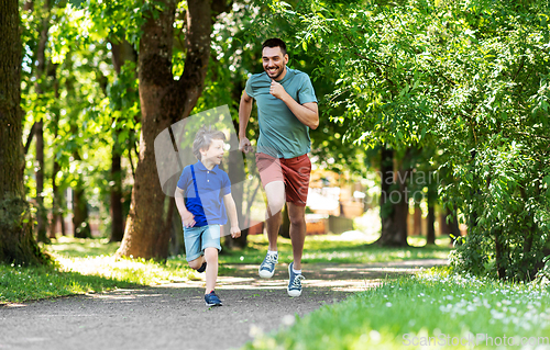 Image of happy father and son compete in running at park