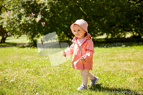 Image of happy little baby girl walking at park in summer