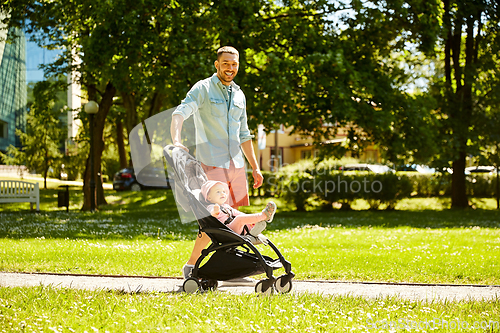 Image of happy father with child in stroller at summer park