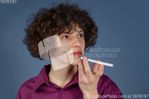 Image of Caucasian young man\'s portrait isolated on blue studio background with copyspace