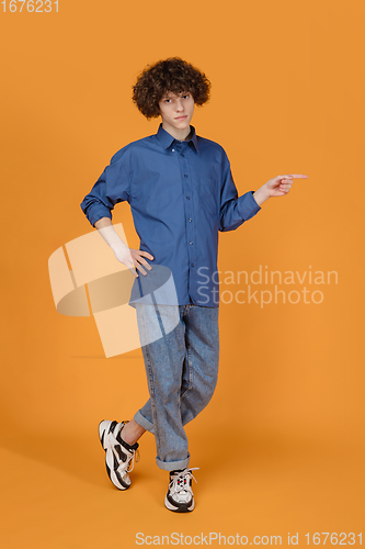 Image of Caucasian young man\'s portrait isolated on yellow studio background with copyspace
