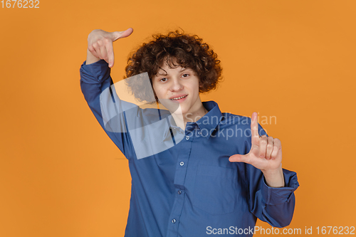 Image of Caucasian young man\'s portrait isolated on yellow studio background with copyspace