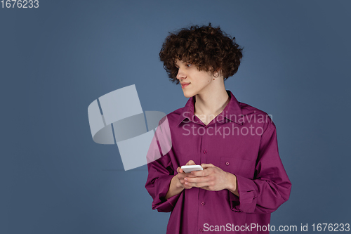 Image of Caucasian young man\'s portrait isolated on blue studio background with copyspace