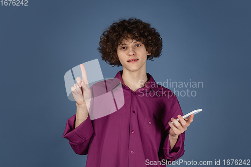 Image of Caucasian young man\'s portrait isolated on blue studio background with copyspace