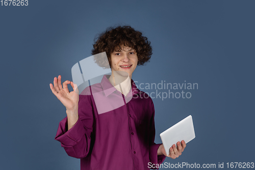 Image of Caucasian young man\'s portrait isolated on blue studio background with copyspace