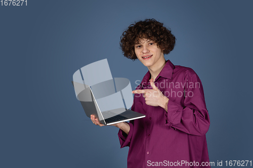 Image of Caucasian young man\'s portrait isolated on blue studio background with copyspace