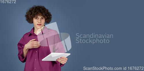 Image of Caucasian young man\'s portrait isolated on blue studio background with copyspace