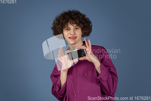 Image of Caucasian young man\'s portrait isolated on blue studio background with copyspace