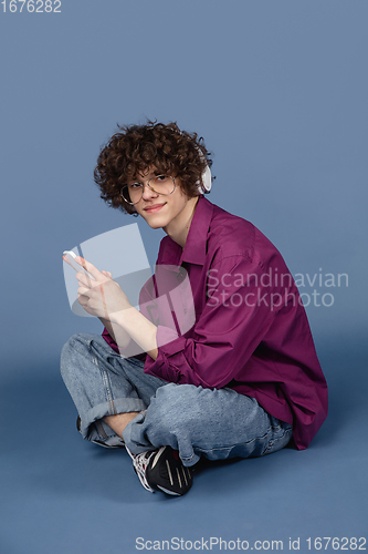 Image of Caucasian young man\'s portrait isolated on blue studio background with copyspace