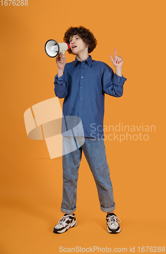 Image of Caucasian young man\'s portrait isolated on yellow studio background with copyspace