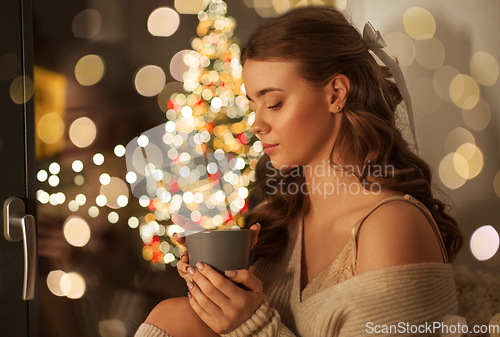 Image of woman with coffee at window on christmas