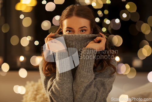 Image of young woman in woolen sweater at night