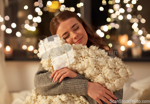 Image of happy young woman with soft pillow in bed at home