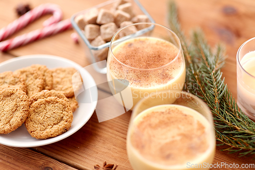 Image of glasses of eggnog, oatmeal cookies and fir branch