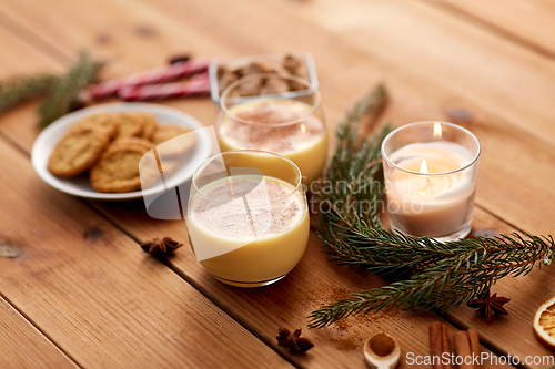 Image of glasses of eggnog, oatmeal cookies and fir branch