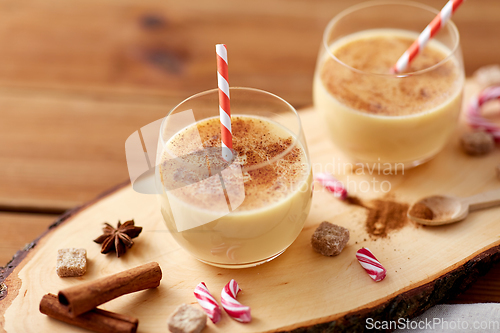 Image of glasses of eggnog, ingredients and spices on wood