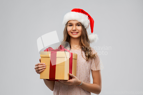 Image of teenage girl in santa hat with christmas gift