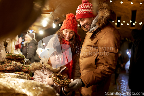 Image of happy family buing wreath at christmas market
