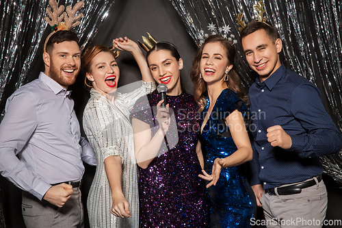 Image of friends with microphone singing at christmas party