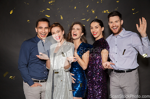 Image of happy friends at party under confetti over black