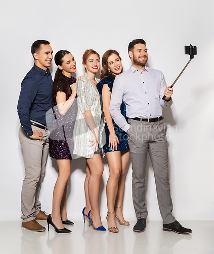 Image of happy friends taking selfie by smartphone at party