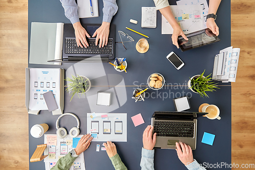 Image of business team with gadgets working at office table