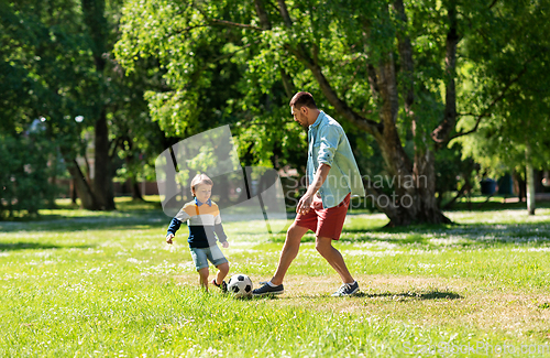 Image of father with little son playing soccer at park