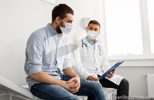 Image of male doctor and patient in masks at hospital