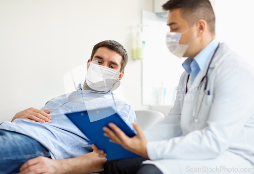 Image of male doctor and patient in masks at hospital