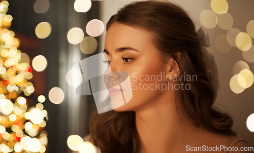 Image of portrait of young woman at home on christmas