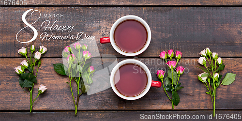 Image of Two cups of tea in shape of number 8 with flowers over wooden background.