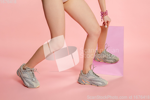 Image of Female fit legs in fashionable shoes on coral pink background with mirror. Style and beauty concept. Close up.