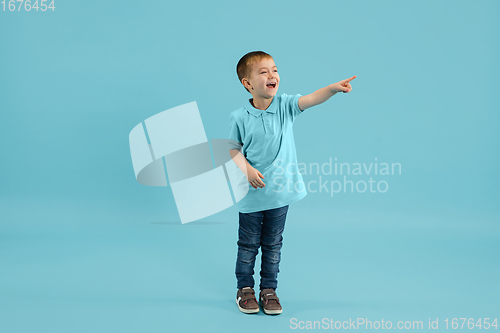 Image of Childhood and dream about big and famous future. Pretty little boy isolated on blue background