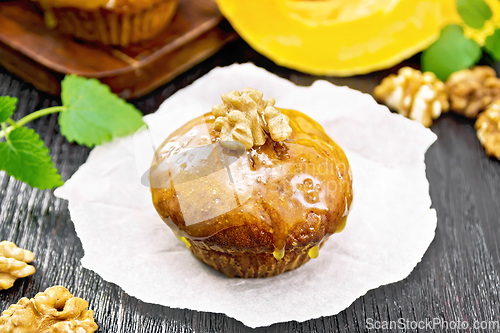 Image of Cupcake pumpkin with orange glaze and walnuts on board