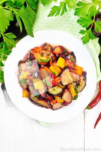 Image of Eggplant with plums in plate on light board top