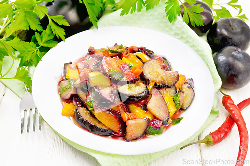 Image of Eggplant with plums in plate on light board