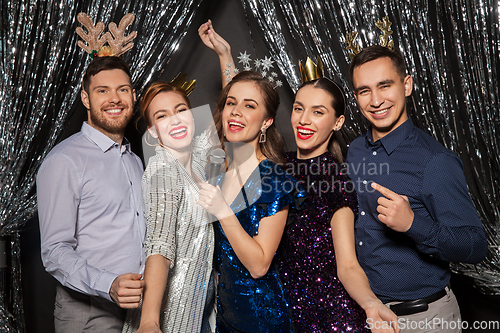 Image of friends with microphone singing at christmas party