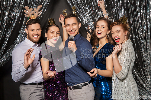 Image of friends with microphone singing at christmas party