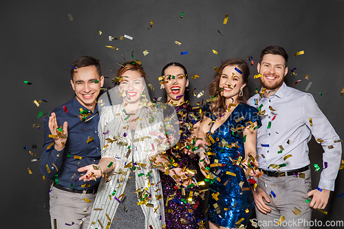 Image of happy friends at party under confetti over black