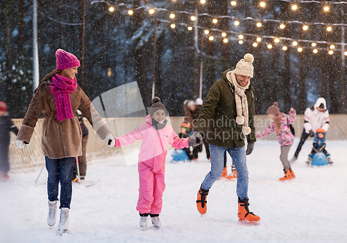 Image of happy family at outdoor skating rink in winter