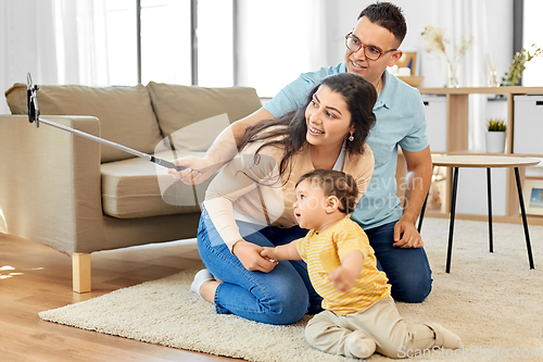 Image of happy family with child sitting on sofa at home