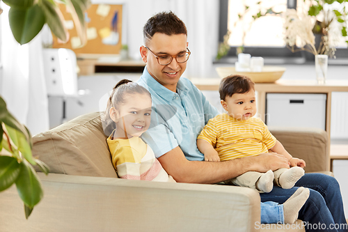 Image of happy father with little children at home