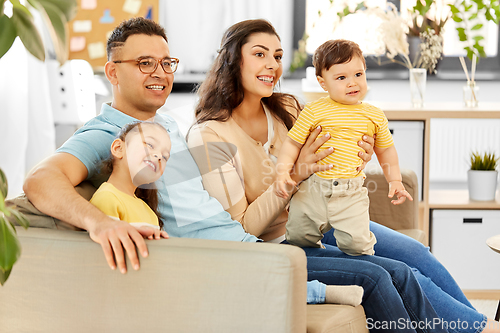 Image of portrait of happy family sitting on sofa at home