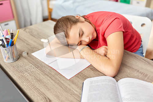 Image of tired student girl sleeping on table at home