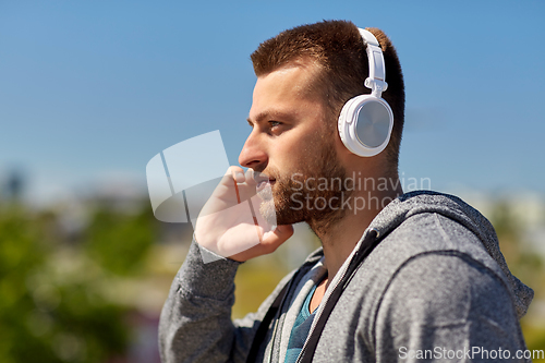 Image of man in headphones listening to music outdoors