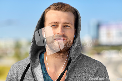 Image of man in earphones listening to music outdoors