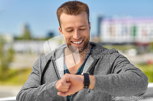 Image of happy man with fitness tracker in city