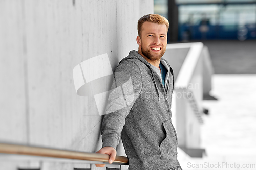 Image of portrait of happy smiling young man outdoors