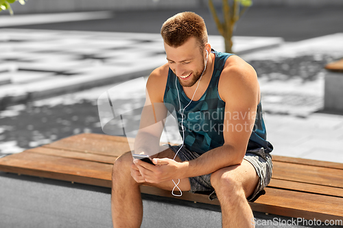 Image of young athlete man with earphones and smartphone