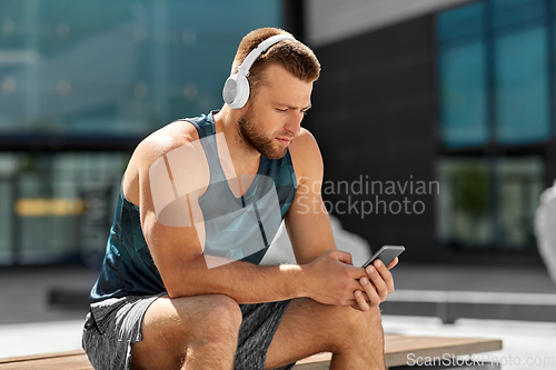 Image of young athlete man with headphones and smartphone
